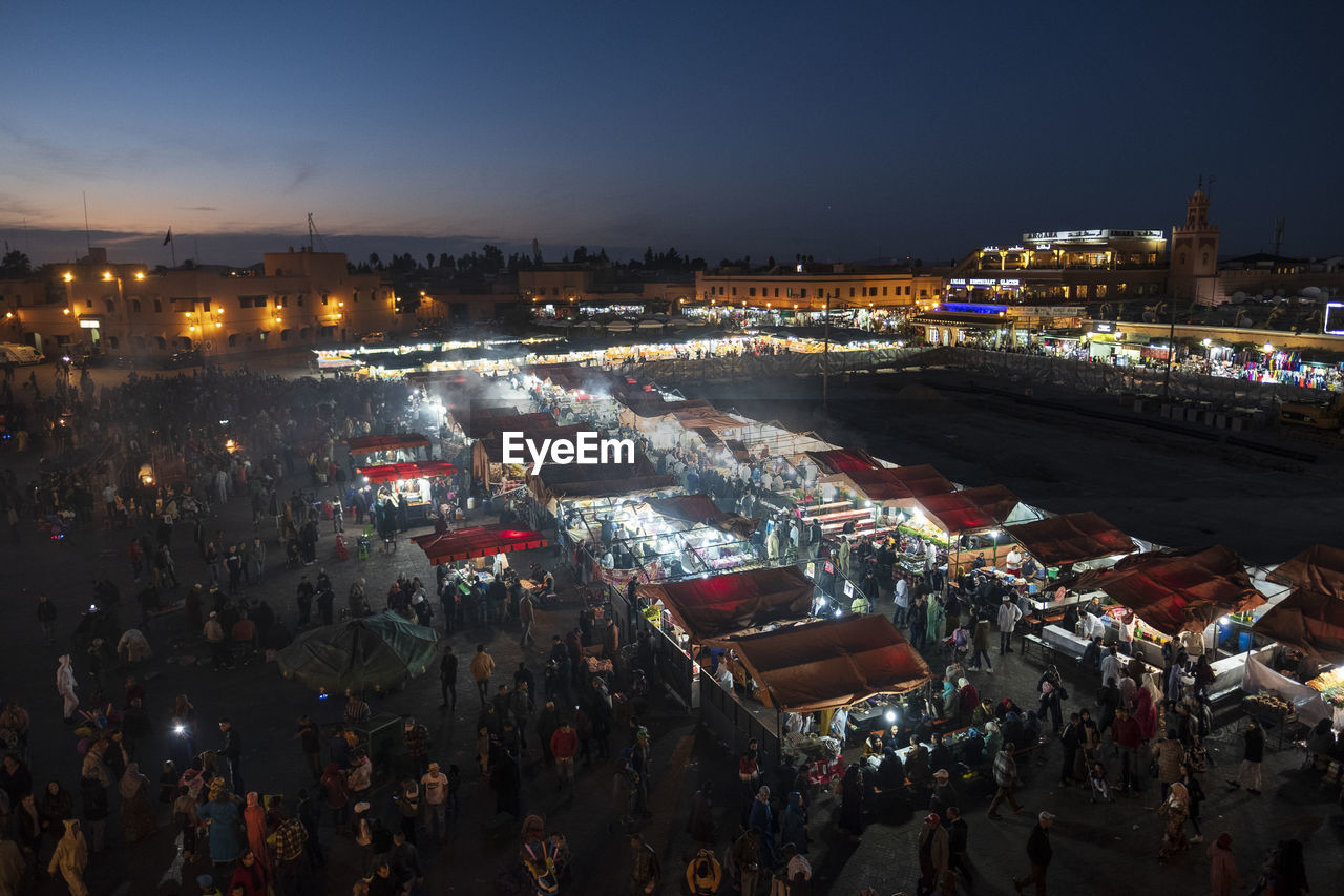 HIGH ANGLE VIEW OF PEOPLE ON STREET AT NIGHT