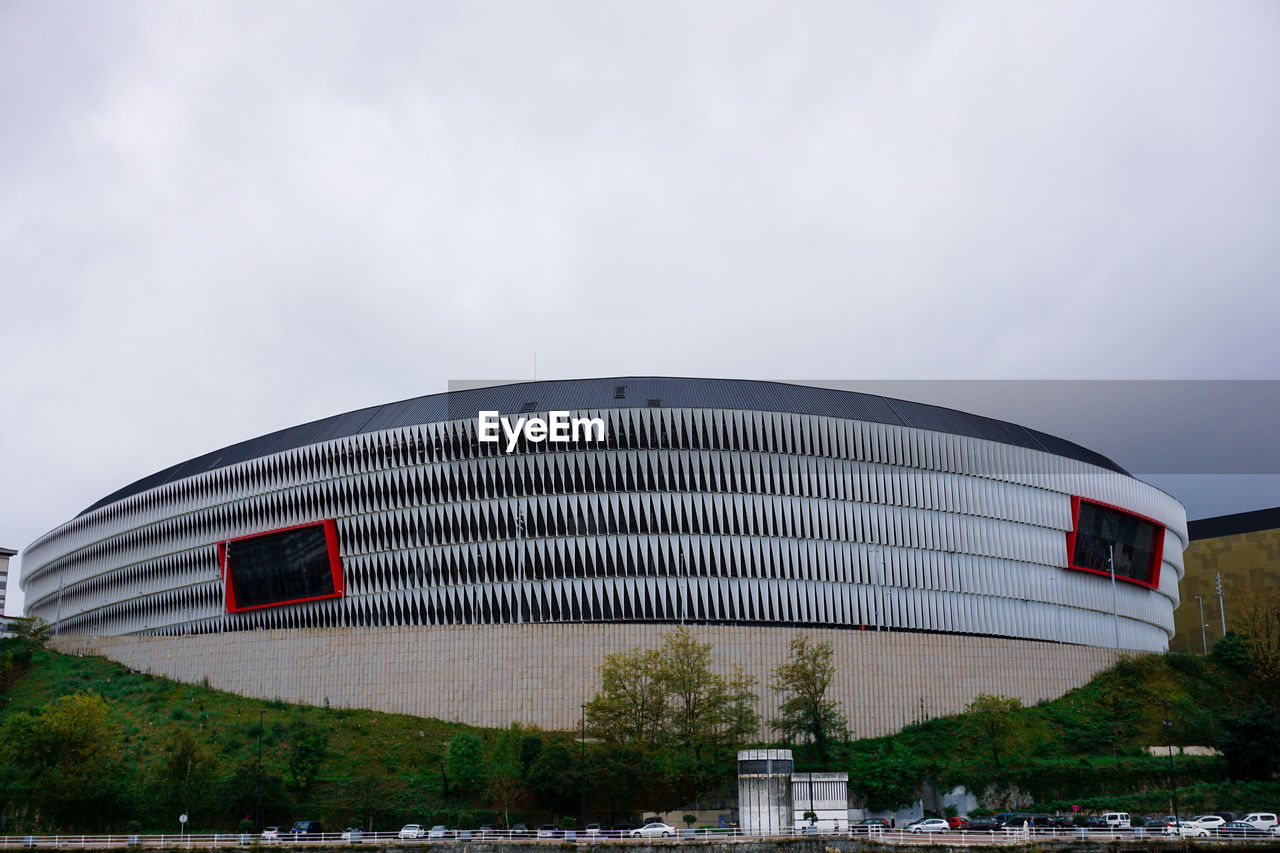 architecture, stadium, built structure, sport venue, building exterior, sky, city, travel destinations, arena, nature, building, travel, water, cloud, no people, transportation, tourism, outdoors, plant, landmark, overcast, theatre, day, environment, industry, business