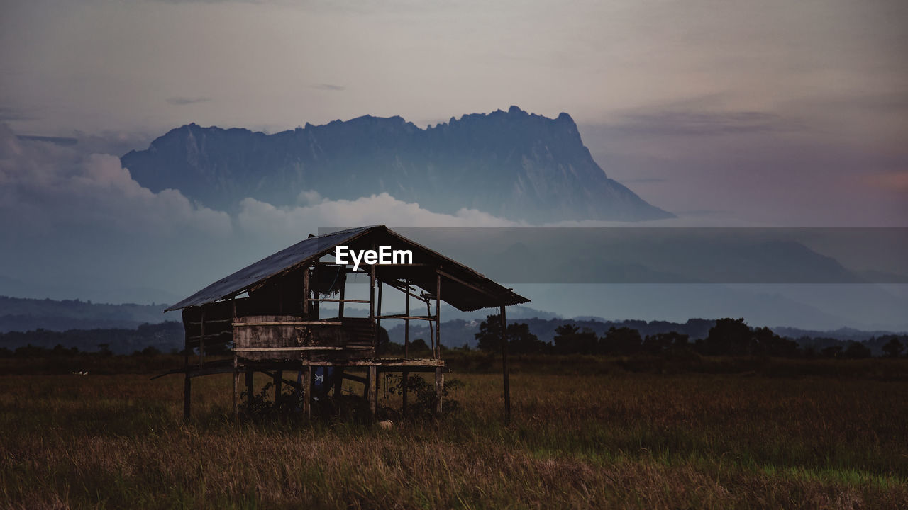 Built structure on field against sky during sunset