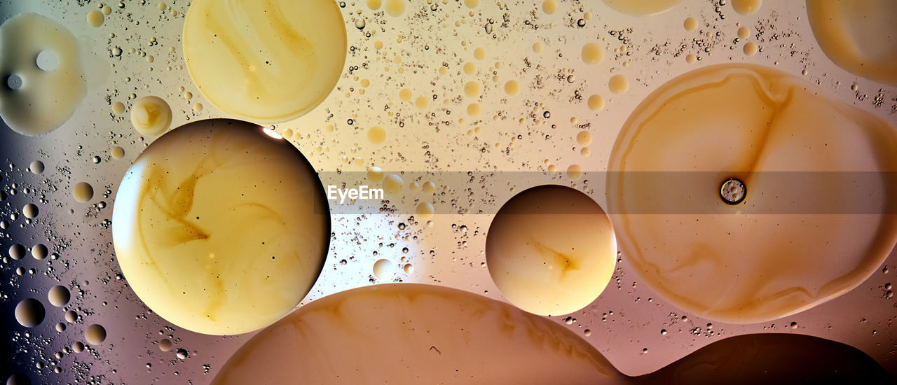 Balls, bubbles and drops in brown, orange and yellow coloring in an abstract surreal arrangement