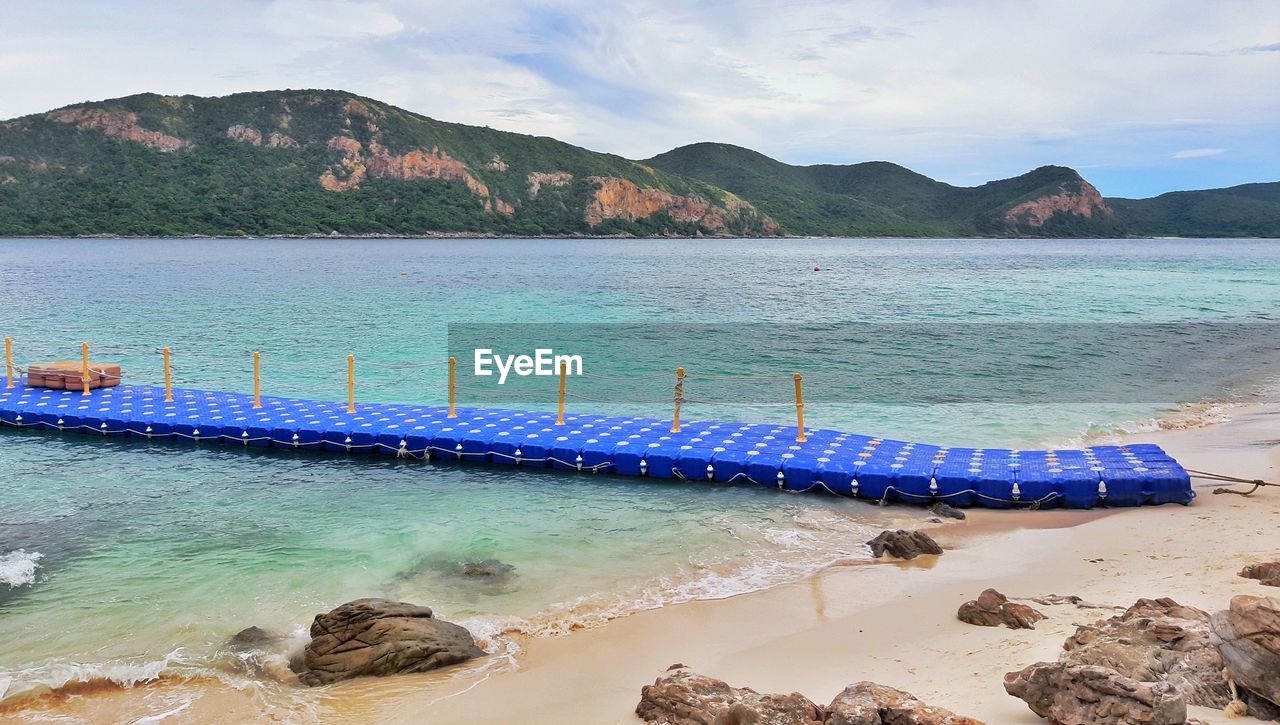 SCENIC VIEW OF SEA AGAINST MOUNTAINS