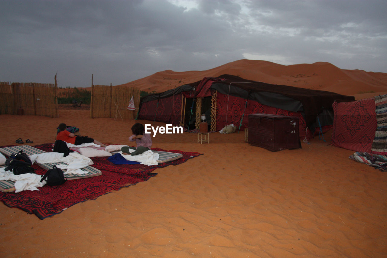 People outside tent on desert land
