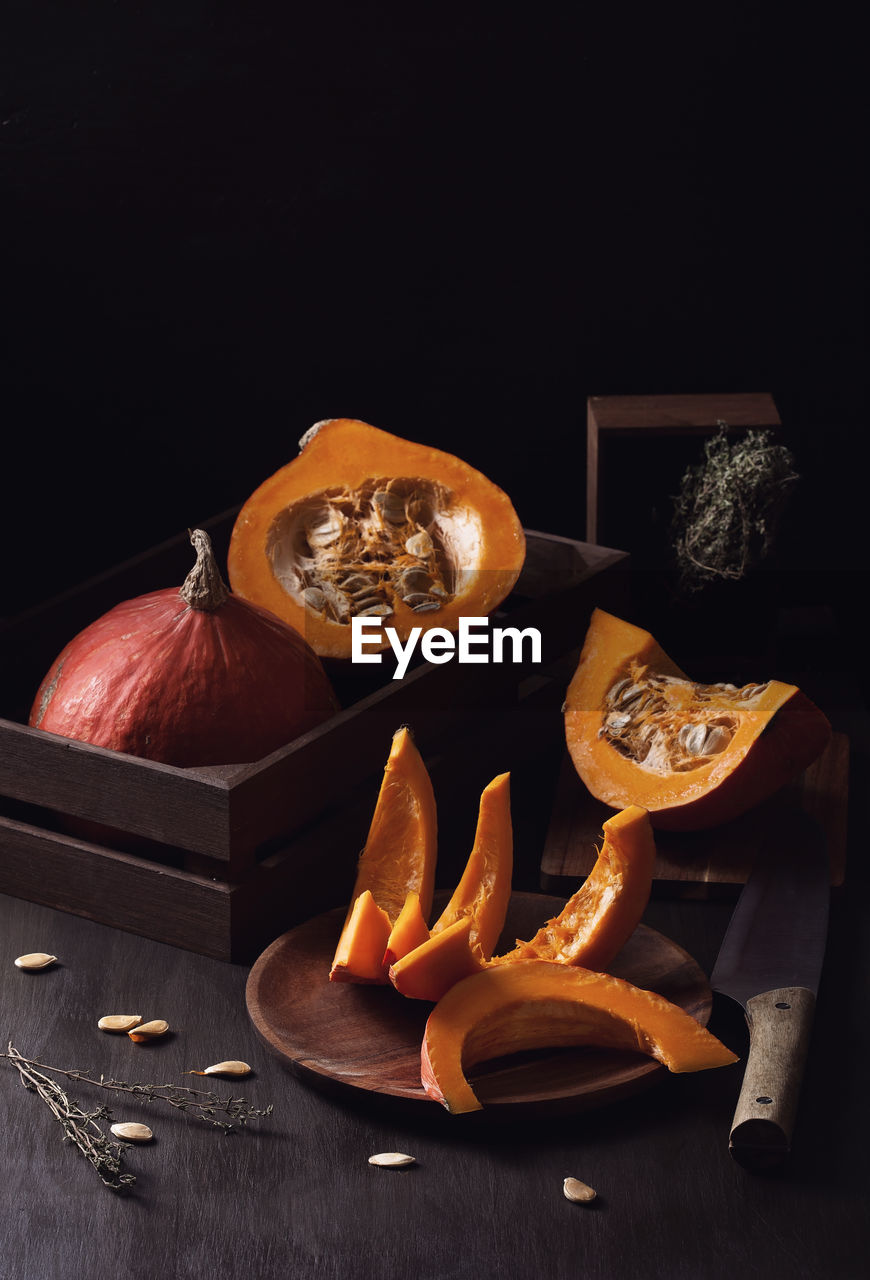 Pumpkins on table against black background