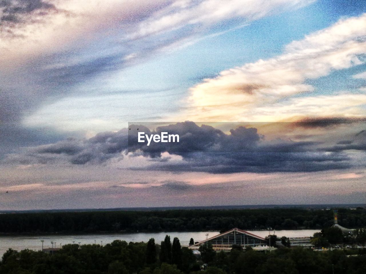 High angle view of trees and river against cloudy sky