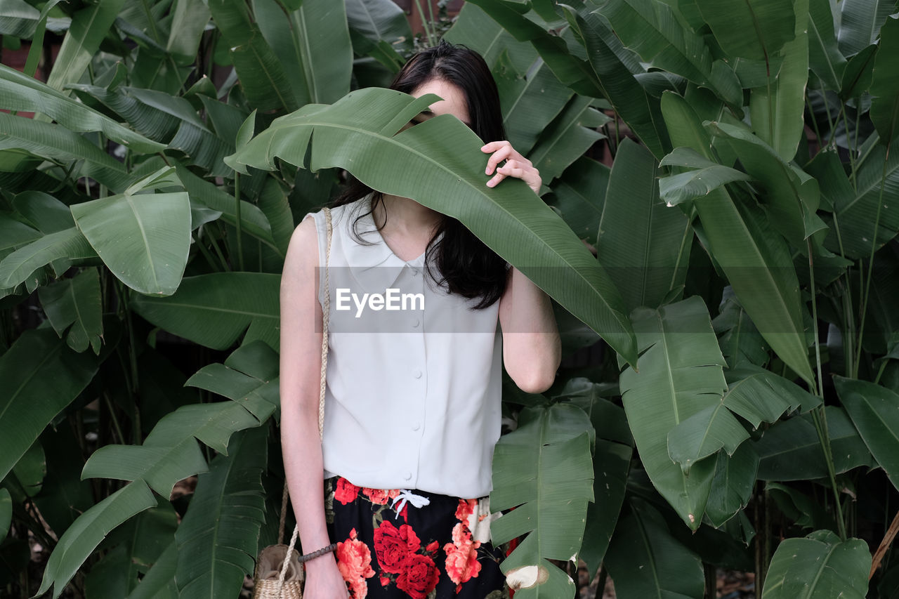 Woman standing by plants