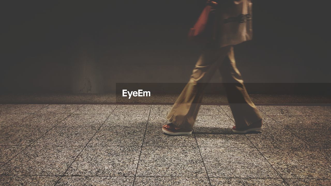 Low section of woman walking on tiled floor