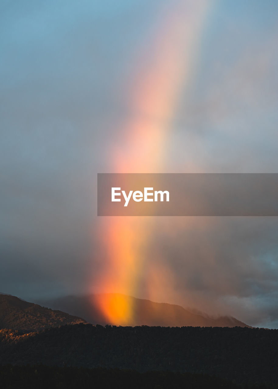 A rainbow captured at sunrise from a distance.