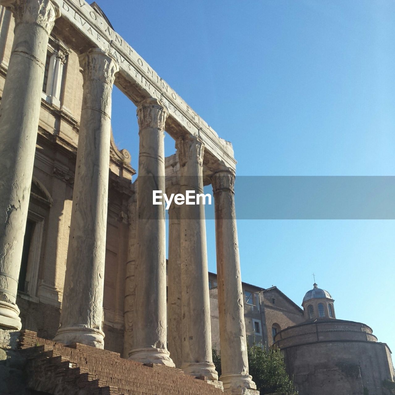 Low angle view of roman forum against blue sky