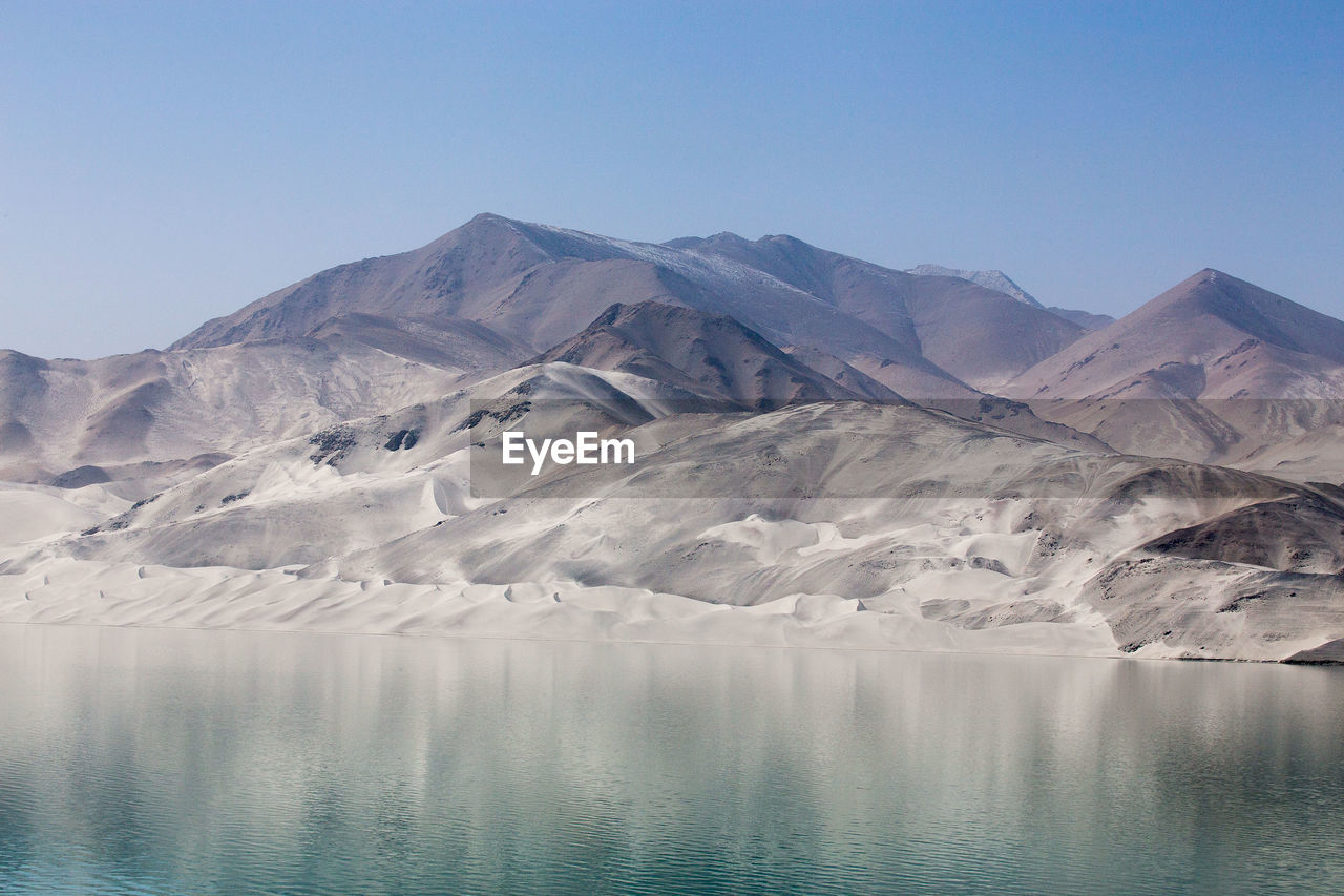 Scenic view of lake and mountains against clear sky