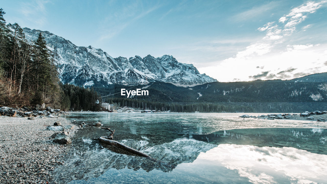 Scenic view of lake by mountains against sky