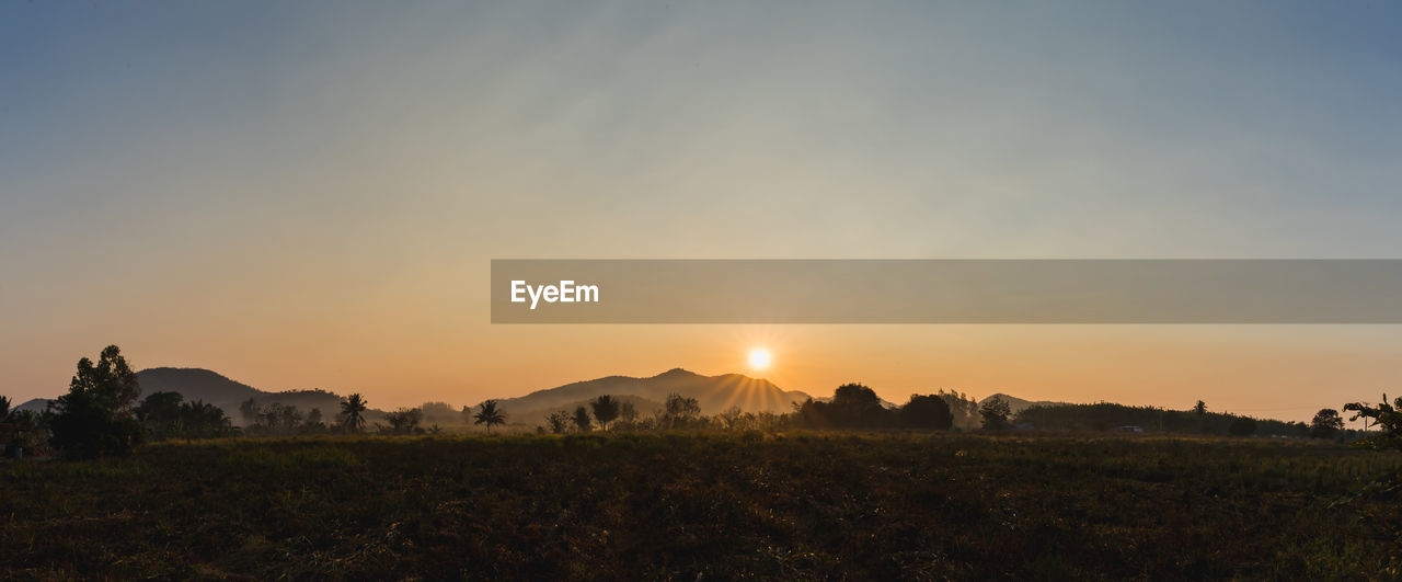 Scenic view of field against sky during sunset