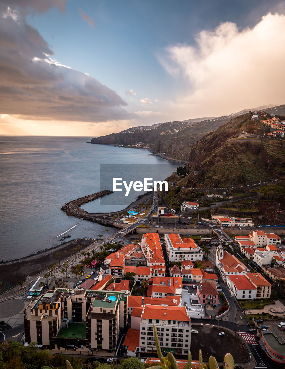 HIGH ANGLE VIEW OF TOWNSCAPE AND SEA AGAINST SKY