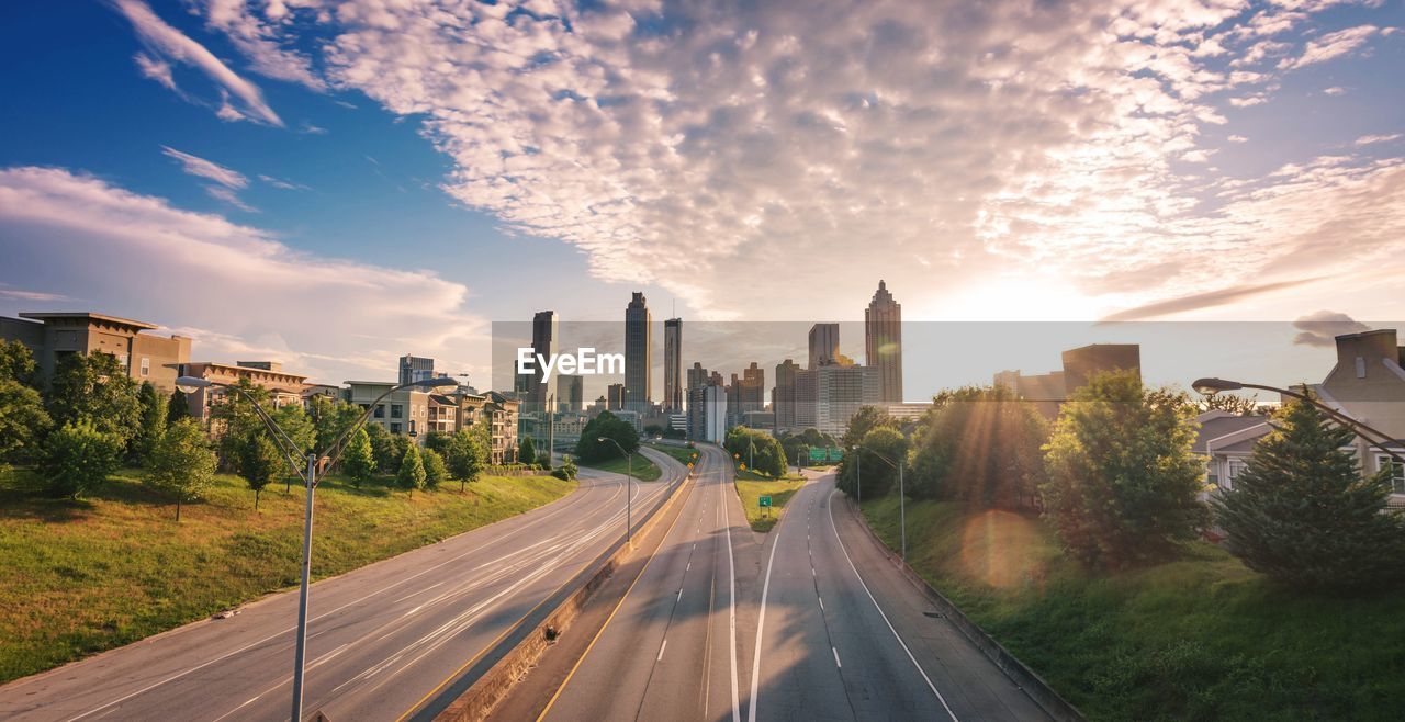 Roads in city against sky during sunset