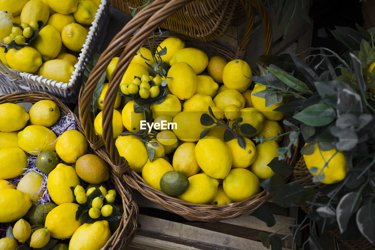 food, food and drink, healthy eating, fruit, yellow, freshness, citrus, basket, wellbeing, container, plant, citrus fruit, produce, abundance, lemon, large group of objects, market, no people, high angle view, retail, organic, market stall, wicker, still life, nature, for sale, outdoors, green, box, agriculture, day, business finance and industry, business, juicy
