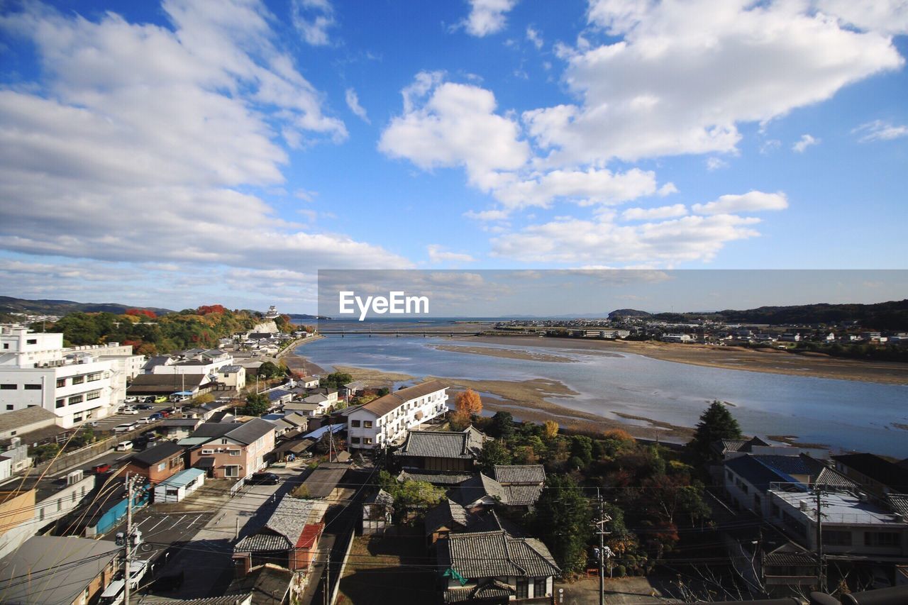 Panoramic view of town by sea against sky