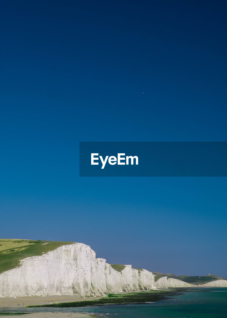 Scenic view of seven sisters against clear blue sky