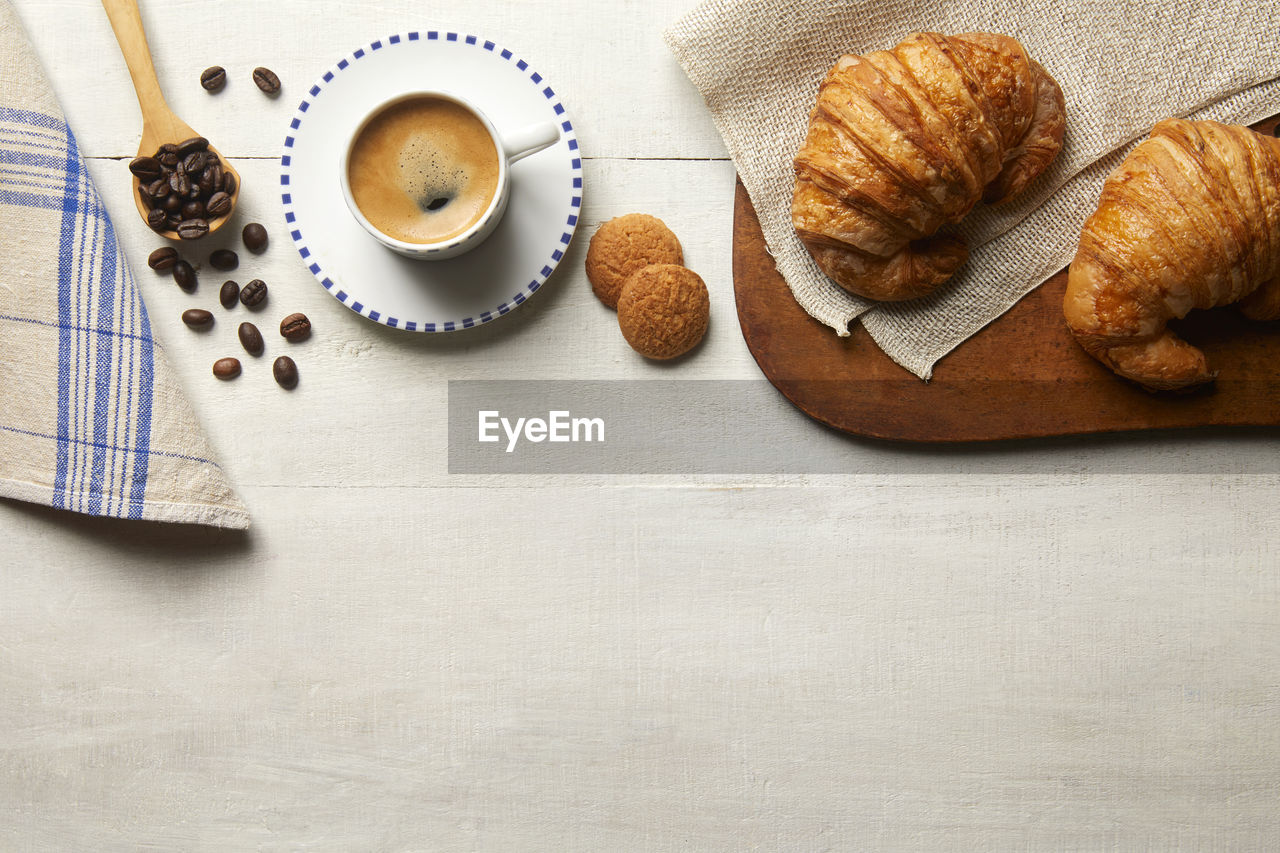 Still life seen from above of a breakfast with coffee and croissants