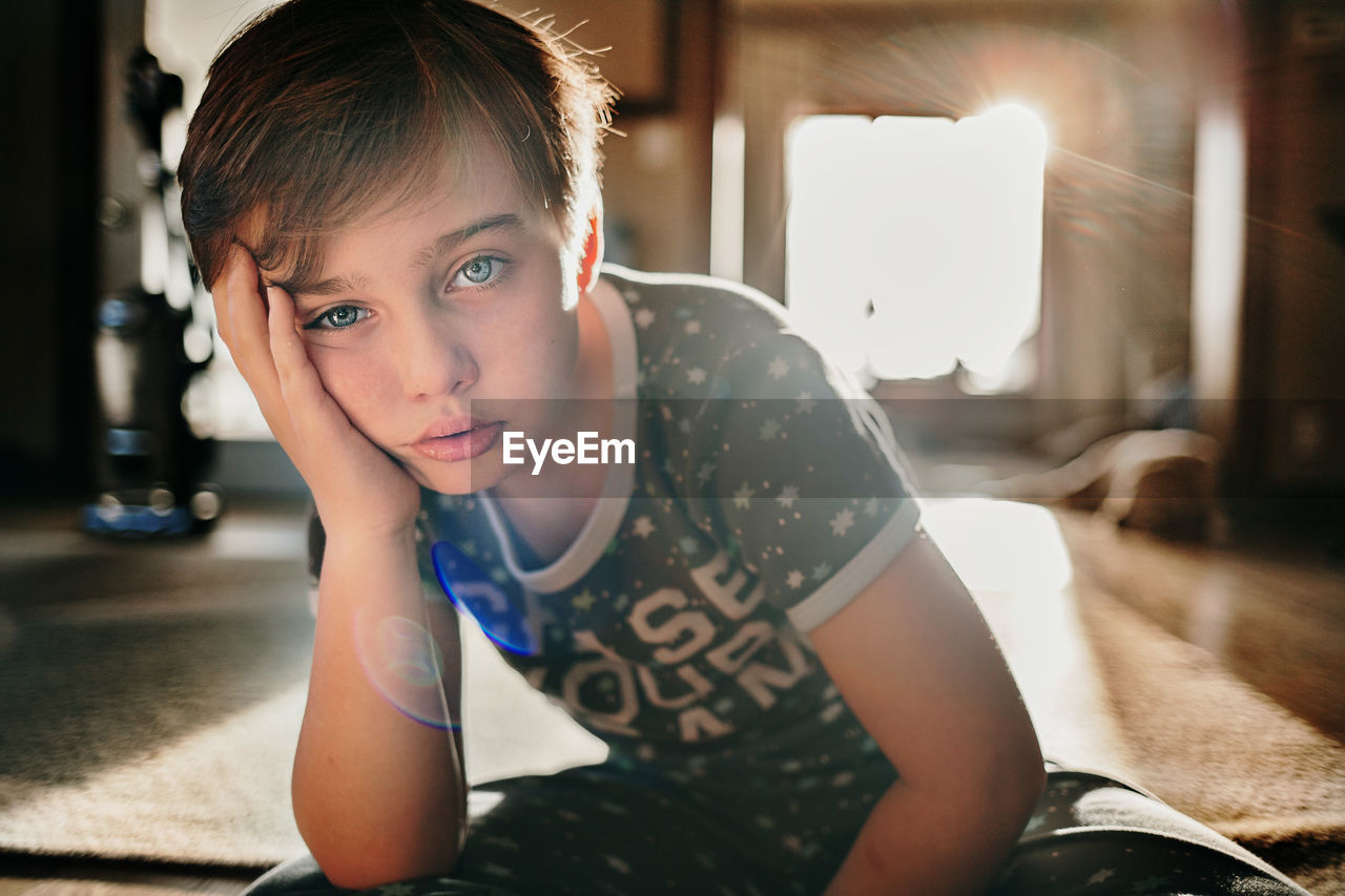 Portrait of young boy sitting at home