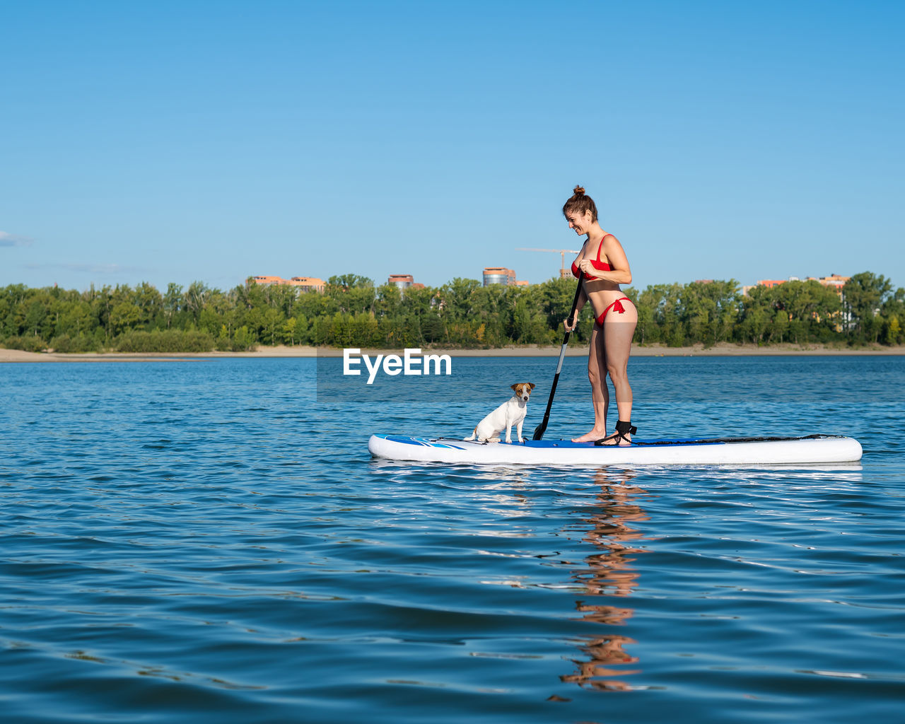 rear view of young woman surfing in lake