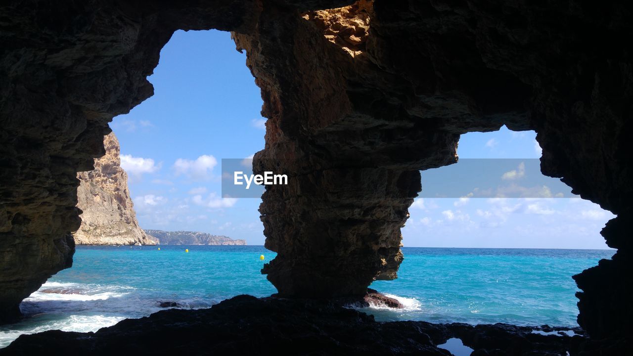 Scenic view of sea seen through cave