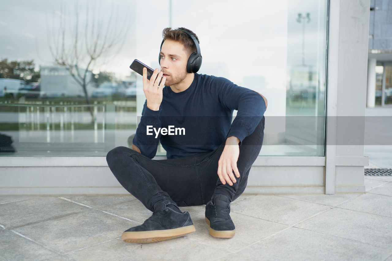 Young man with headphones on city street