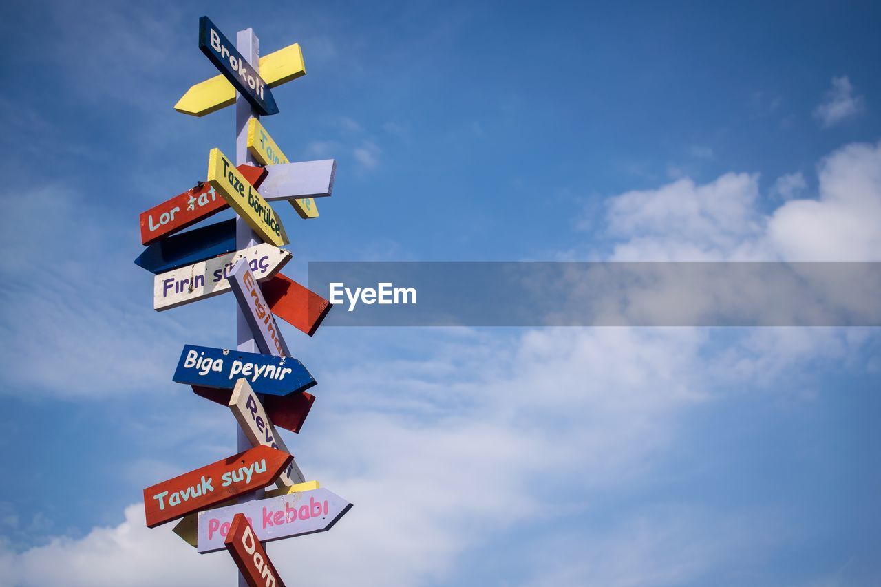 Low angle view of colorful road signs against sky