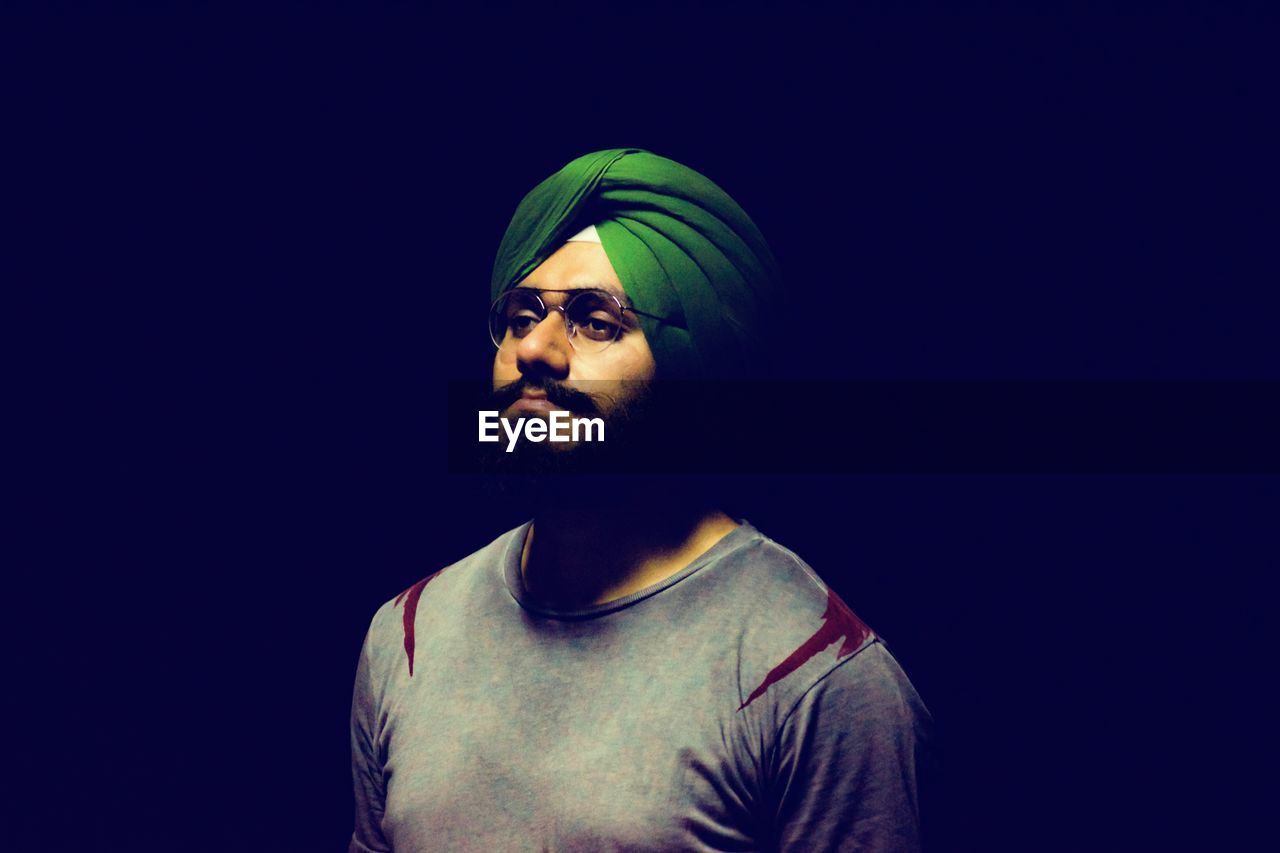 Man in turban against black background