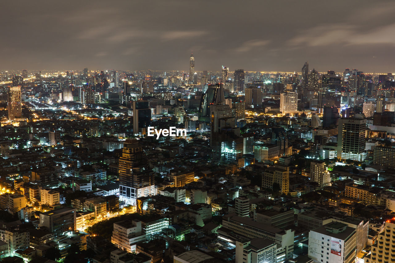 Illuminated cityscape against sky at night