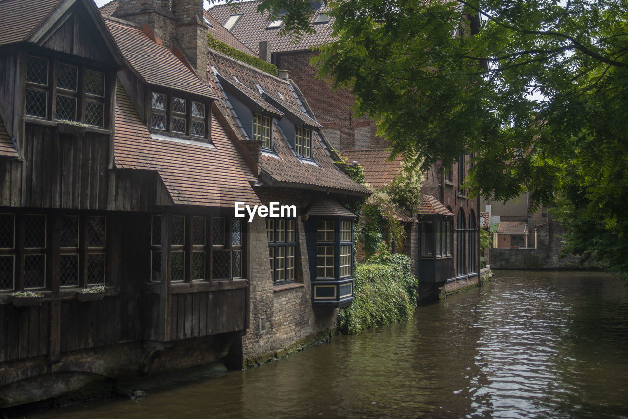 HOUSES BY RIVER AGAINST BUILDINGS