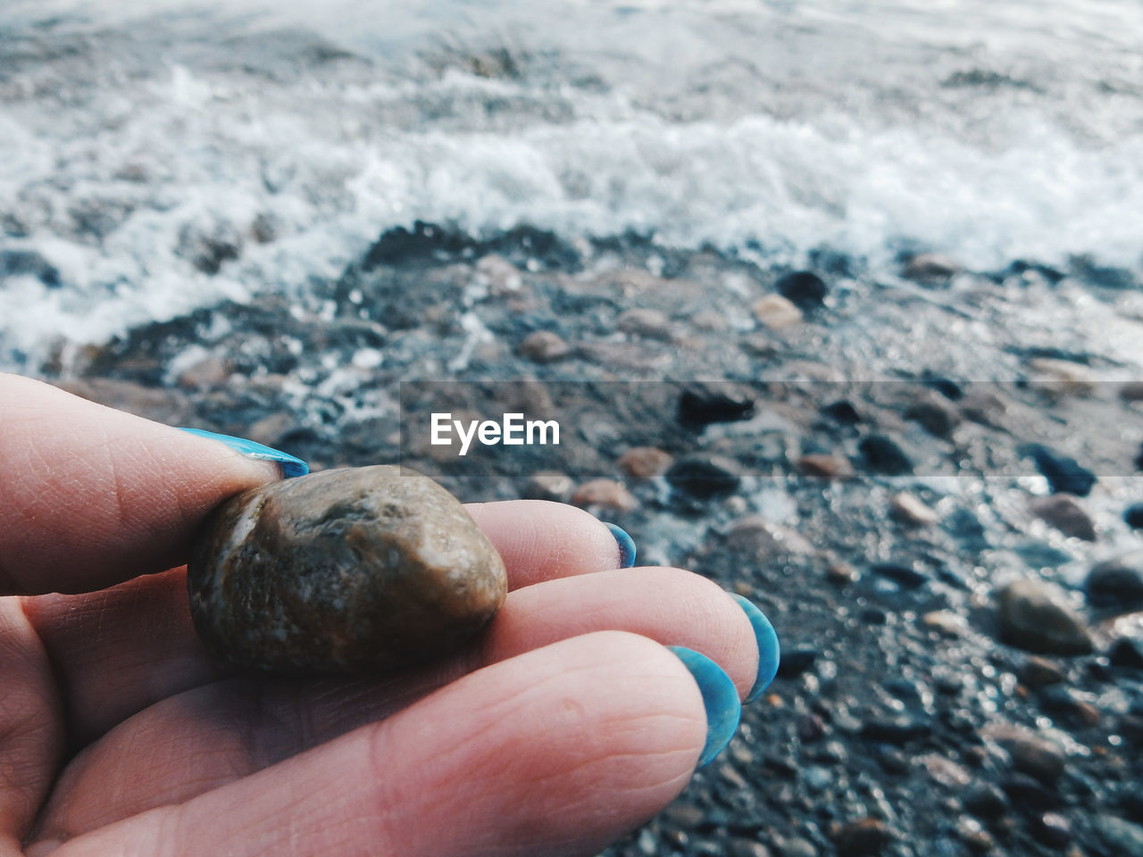 Close-up of hand holding pebble