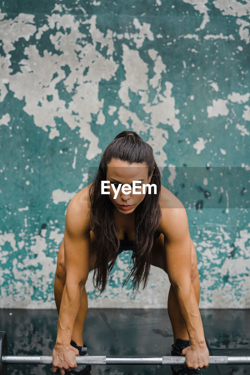 Fit woman lifts weights in rain at an outdoor gym