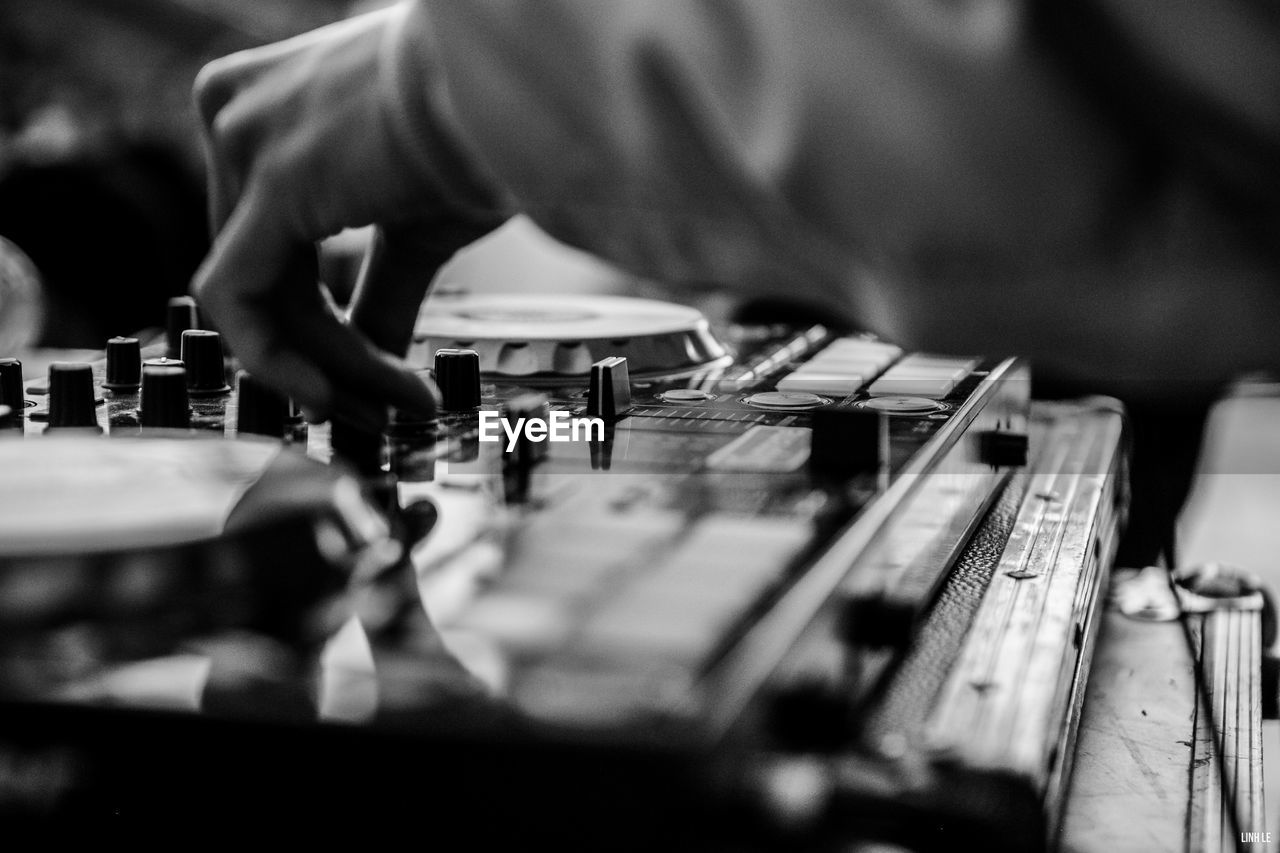 Cropped hand of person adjusting knob of sound mixer