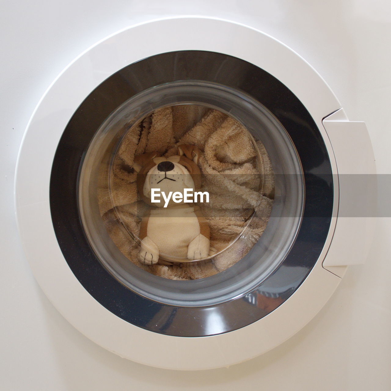 Stuffed toy and clothes in washing machine drum