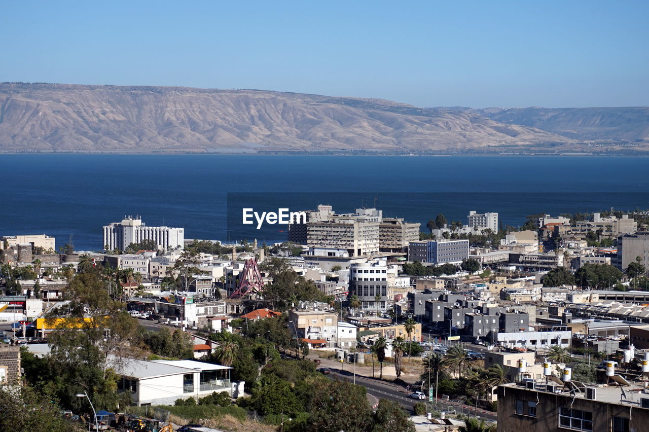 High angle view of buildings by sea against sky