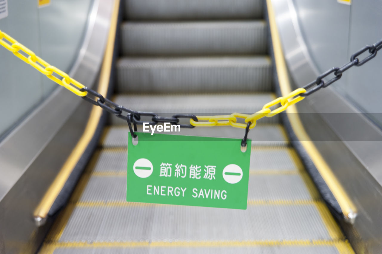 Close-up of metallic chain over escalator
