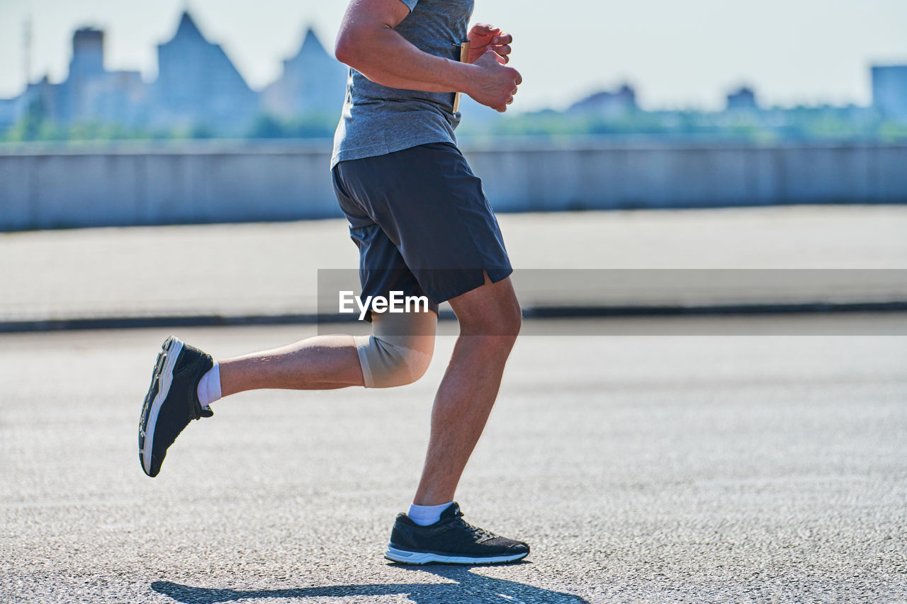 Running man. athletic man jogging in sportswear on city road. street workout, sprinting outdoor