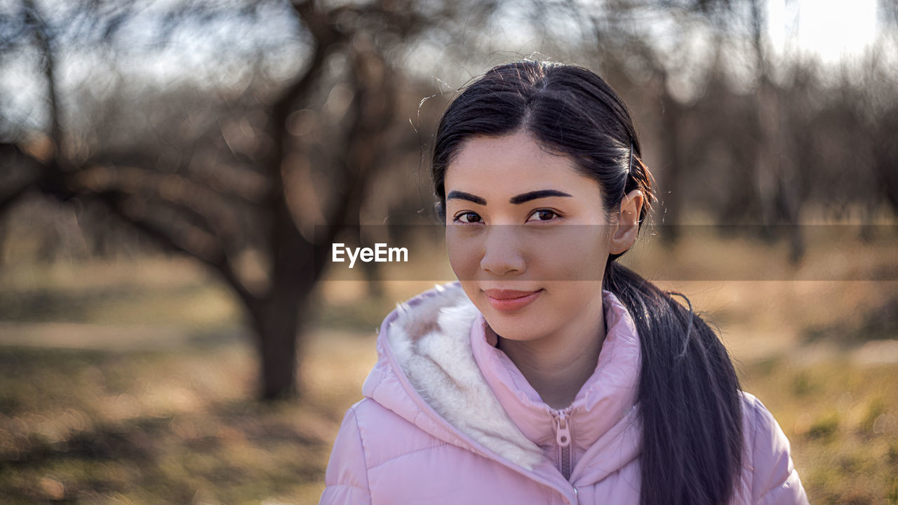 Portrait of beautiful woman standing on field