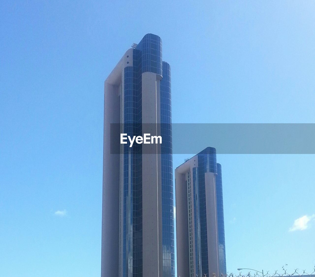 LOW ANGLE VIEW OF SKYSCRAPER AGAINST BLUE SKY