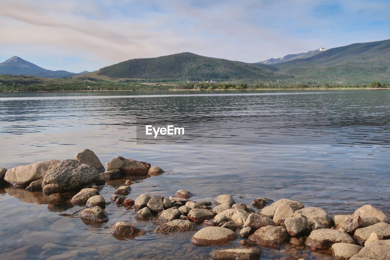 Rocks in lake against sky