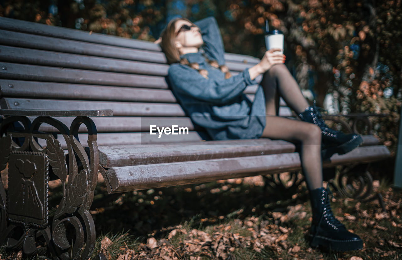 Woman sitting on bench in park