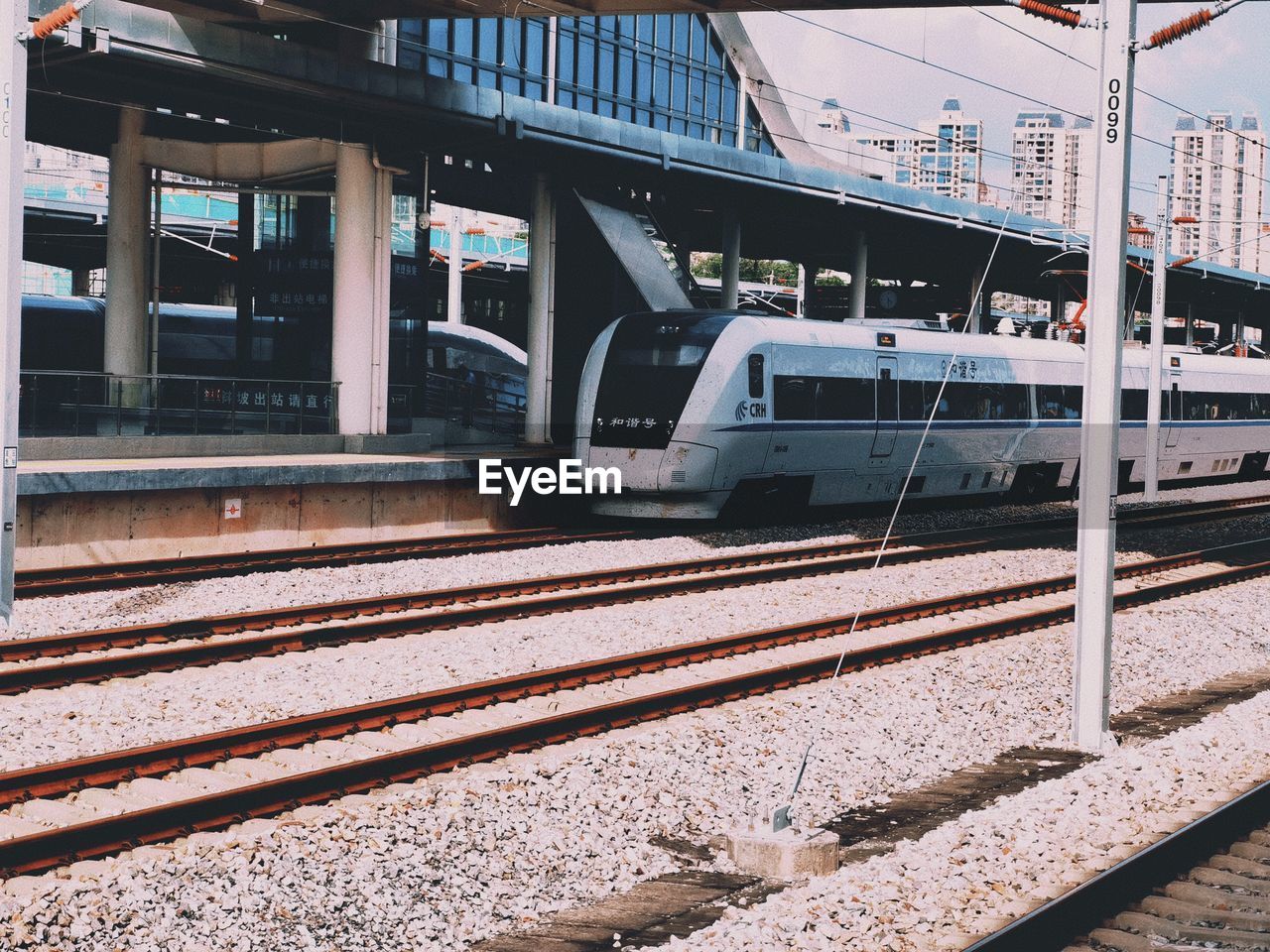 TRAIN ON RAILROAD STATION PLATFORM IN CITY