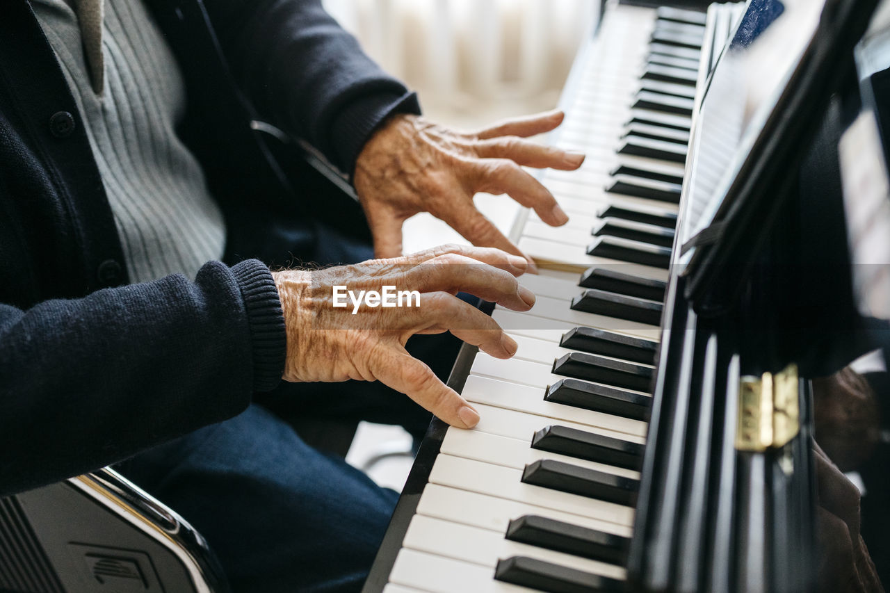 Crop view of senior man playing piano