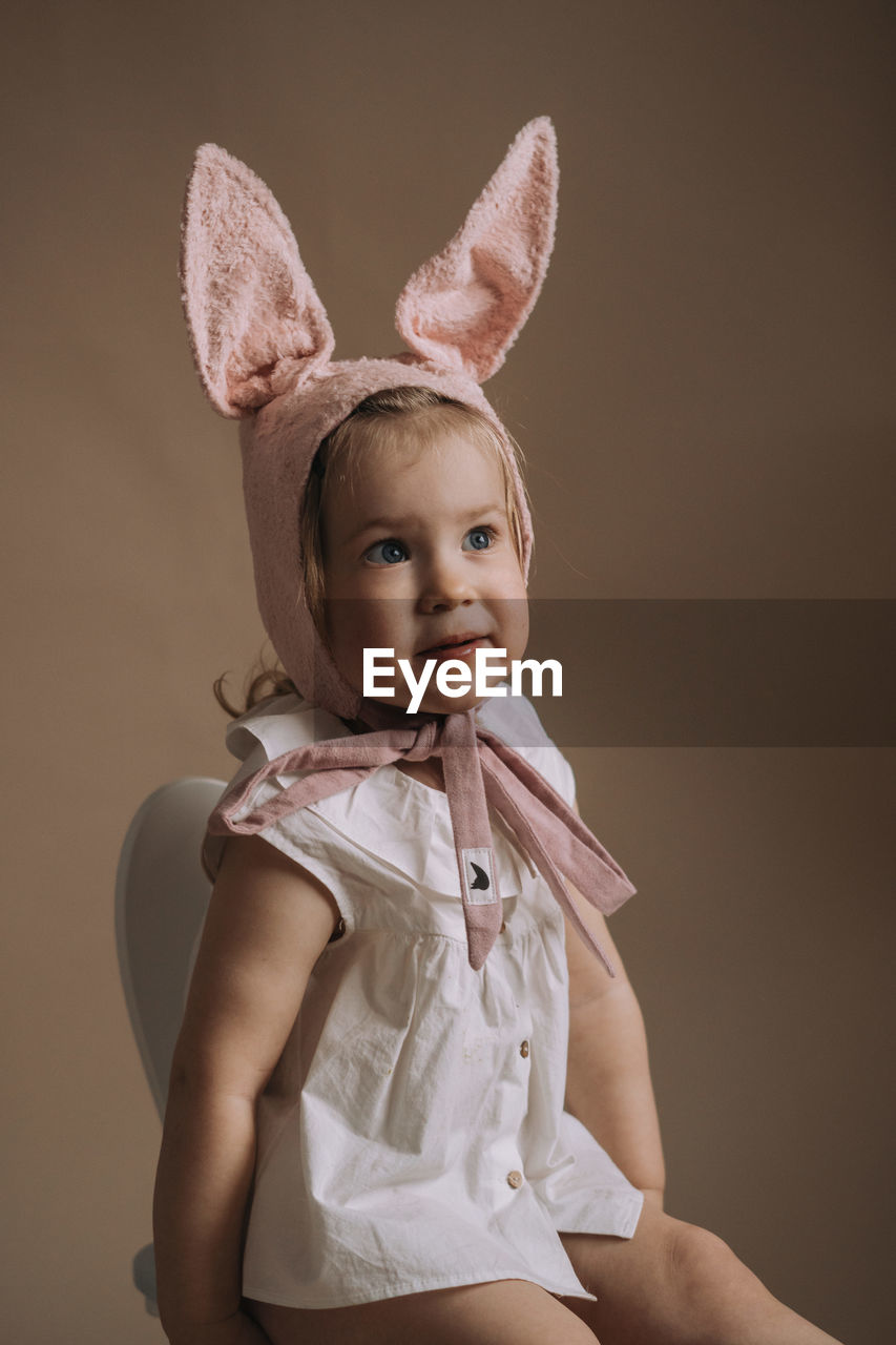 Toddler baby girl in funny hat with ears having fun