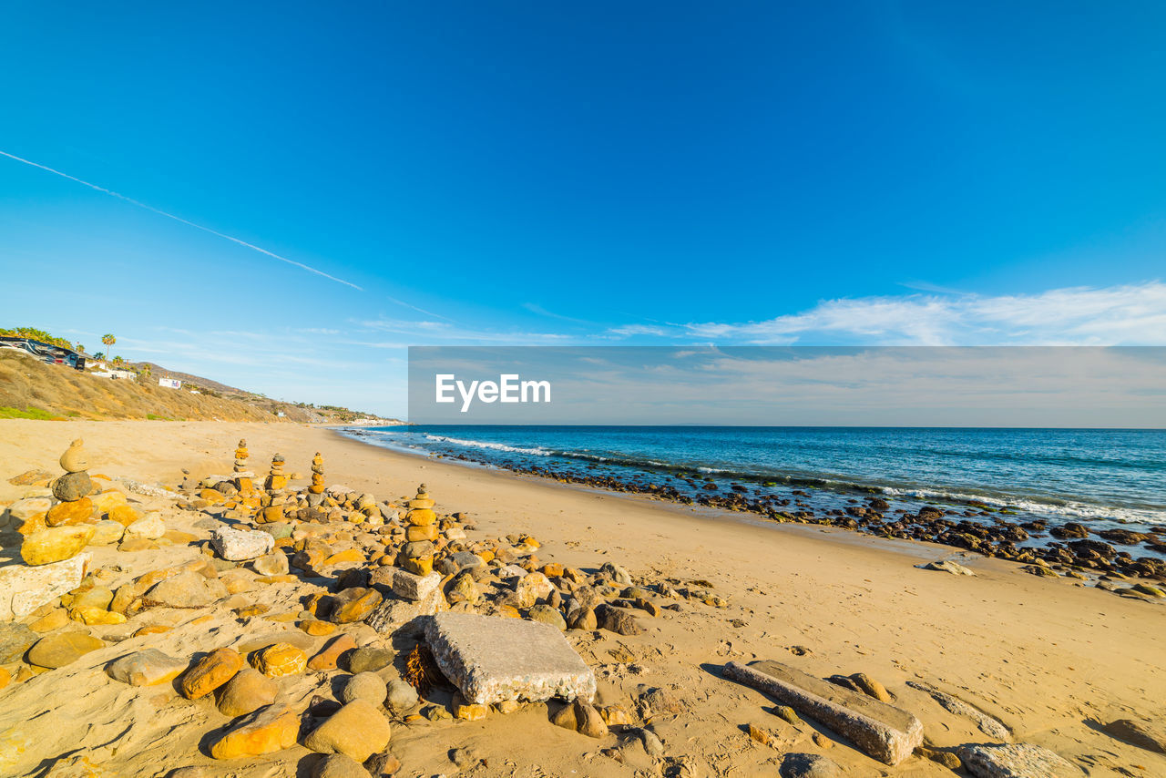 Scenic view of beach against blue sky