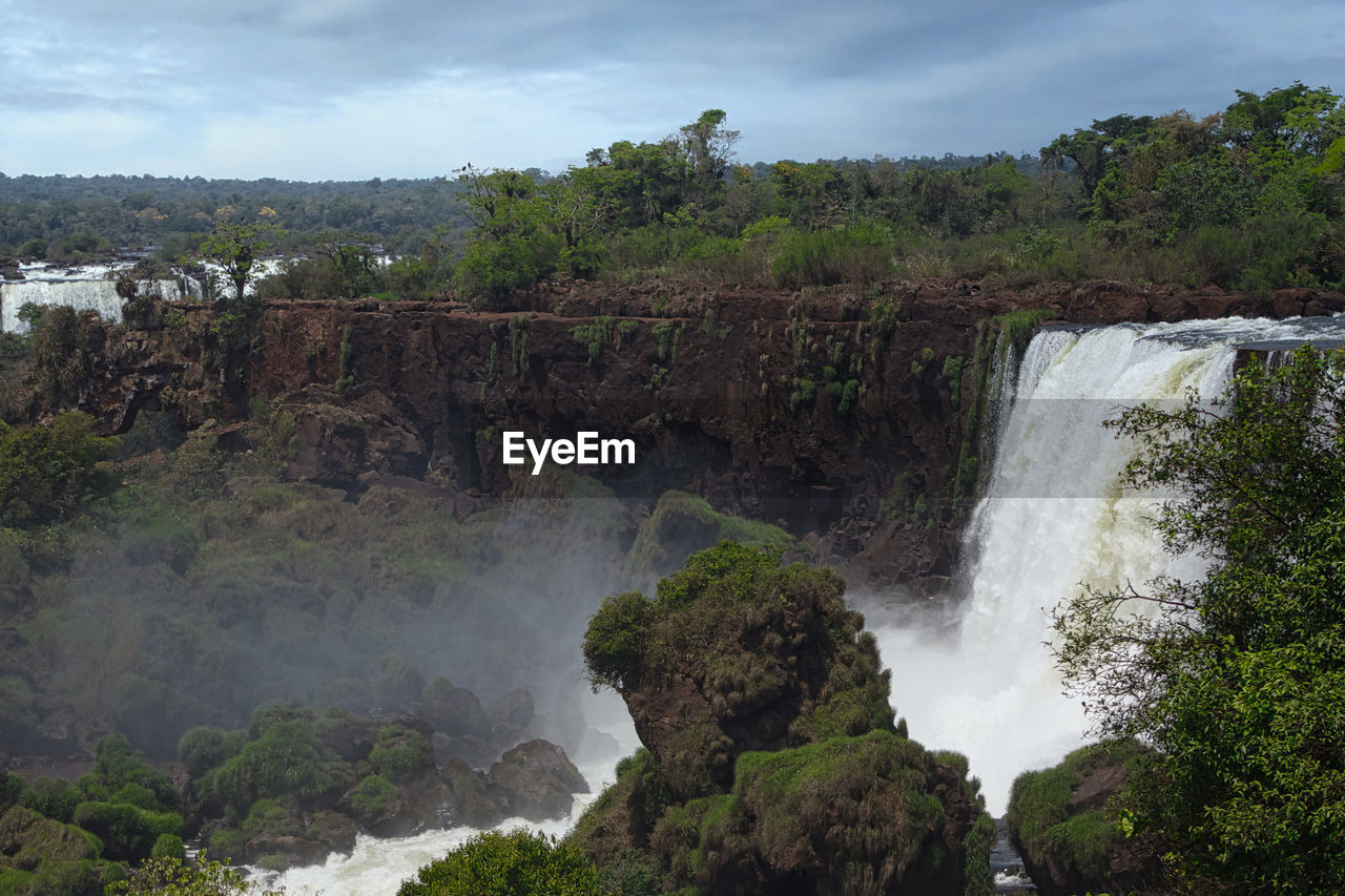 Scenic view of waterfall against sky