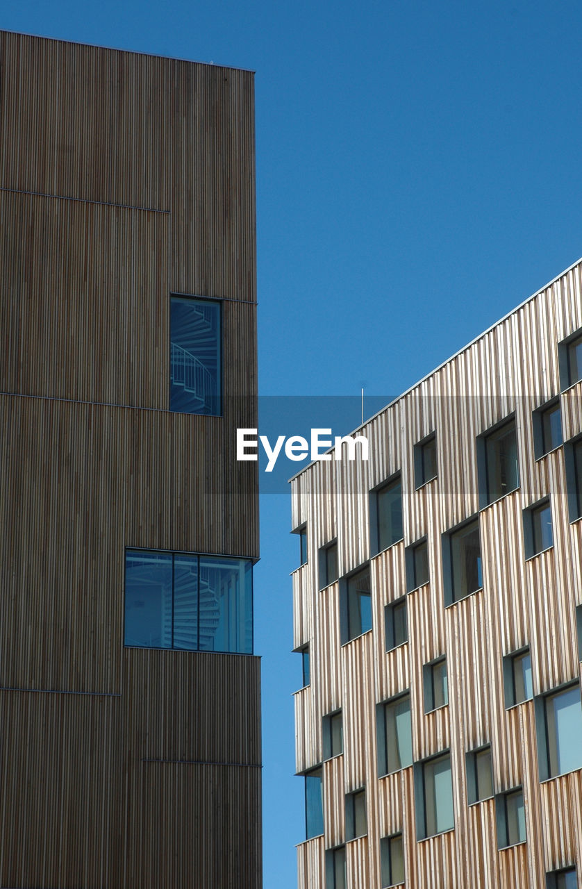 LOW ANGLE VIEW OF MODERN BUILDING AGAINST BLUE SKY