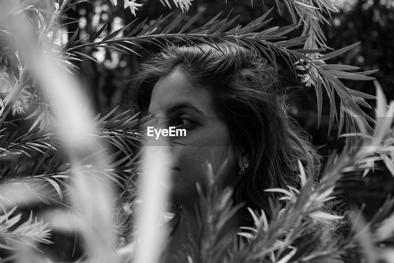 Close-up of woman looking away by plants