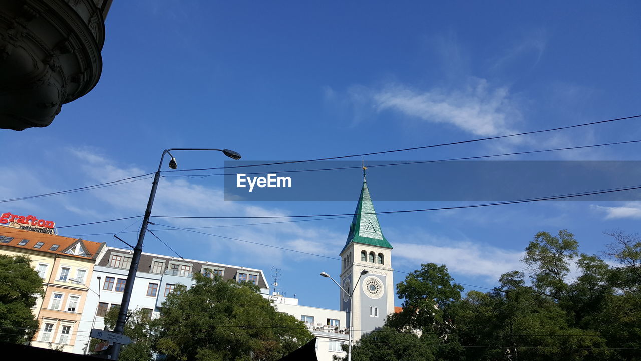 LOW ANGLE VIEW OF TREES AND BUILDING AGAINST BLUE SKY