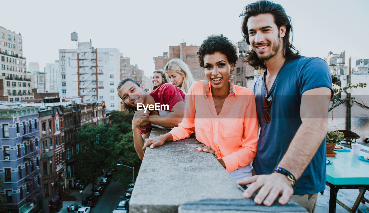 Portrait of smiling young couple sitting in city