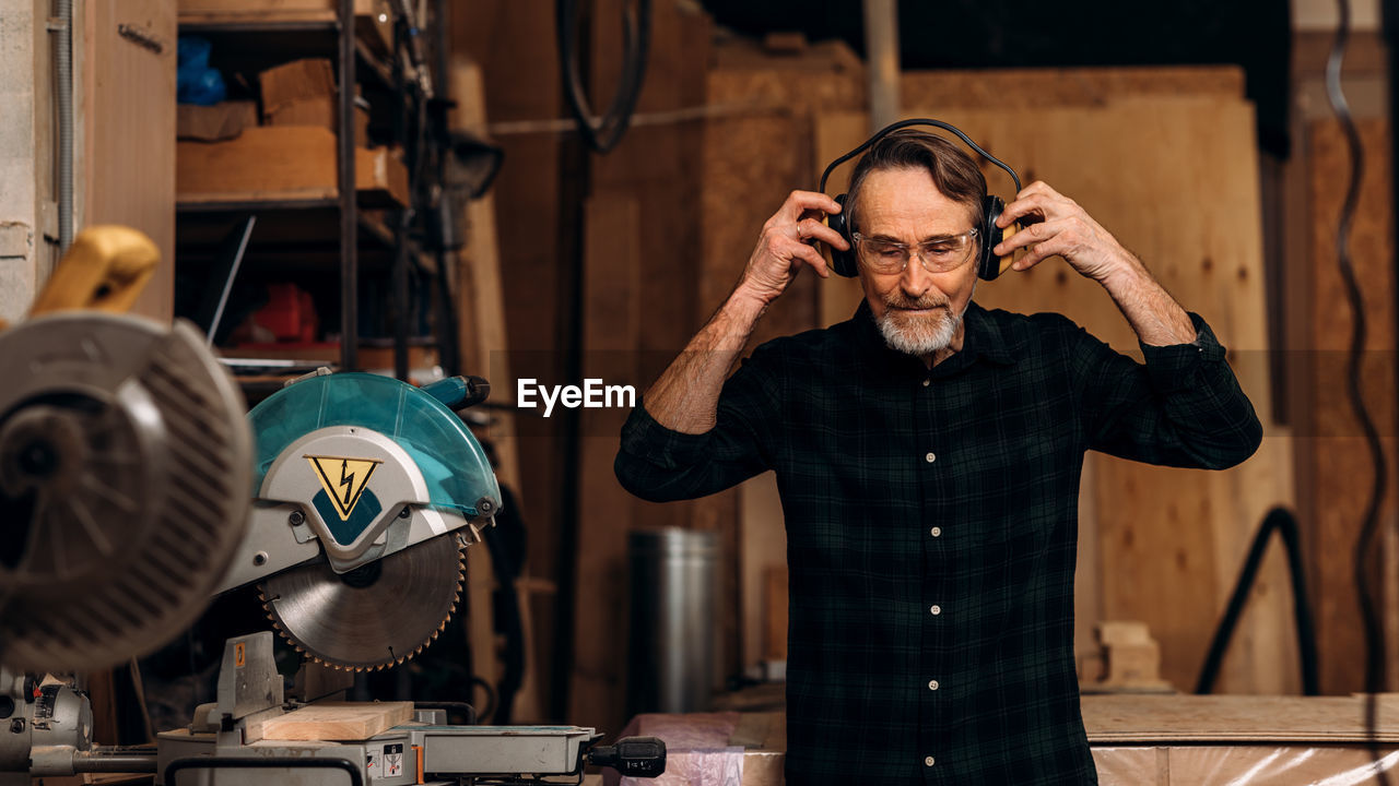 Carpenter wearing ear muffs at workshop